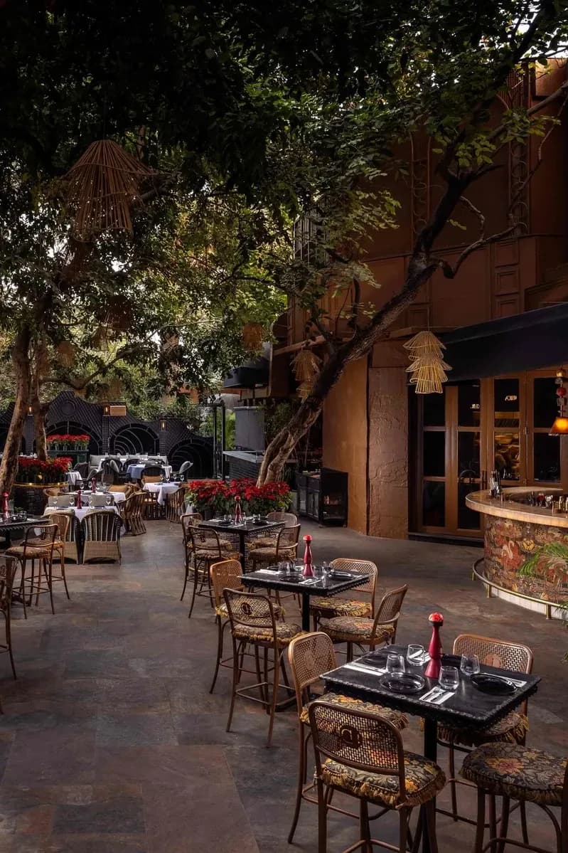 Chica's Fountain Court — lantern-lit courtyard dining beneath sculpted foliage